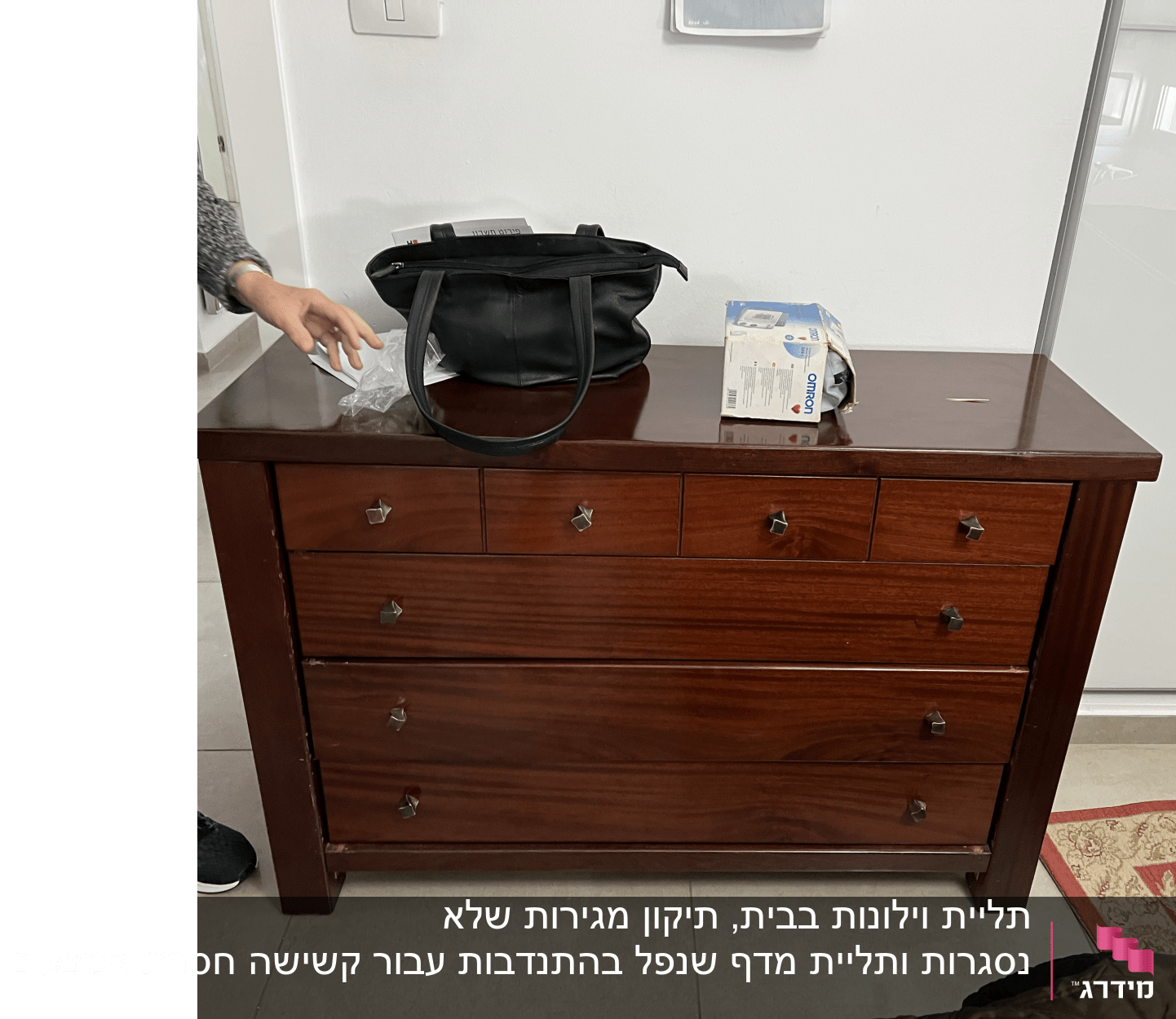 יד מושטת ליד שידה עם קופסת כלים